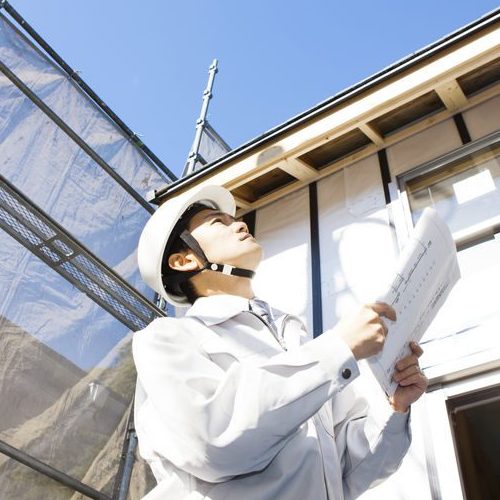 Man With Clipboard Inspecting a Roof