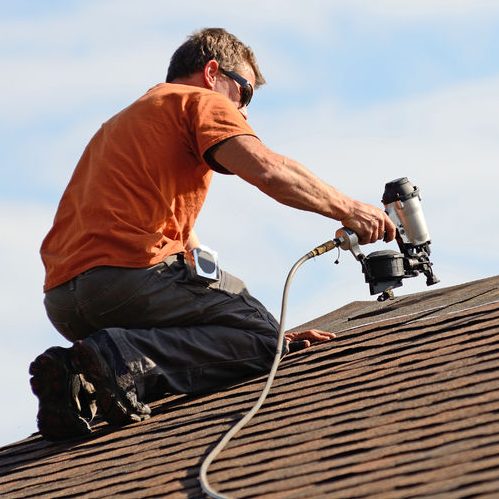 Roofer Putting Asphalt Roofing on an Apartment